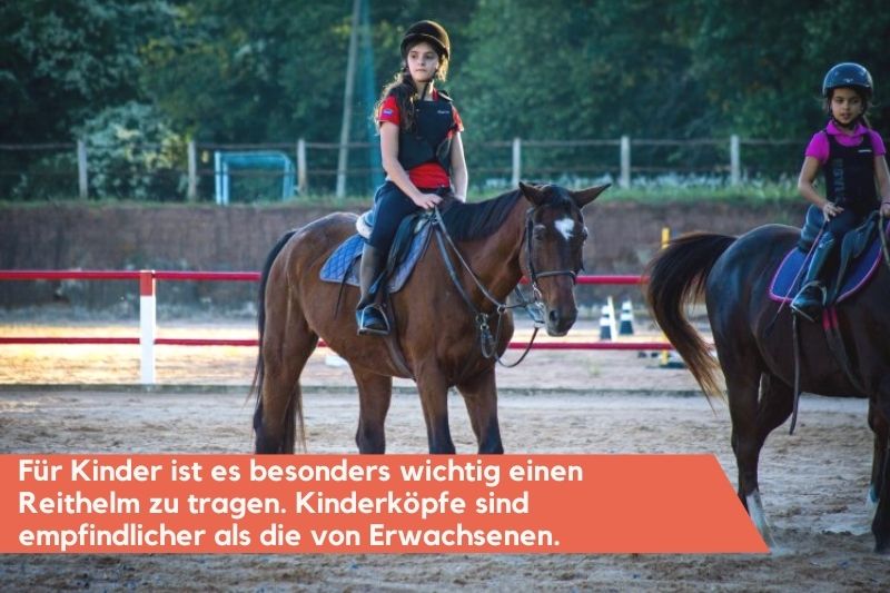 Kinder mit Reithelmen auf dem Pferd